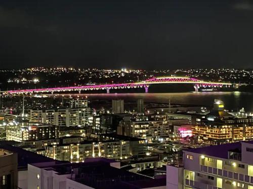 a view of a city at night with a bridge at Skytower view and Seaview 2 bedroom Apartment in Auckland