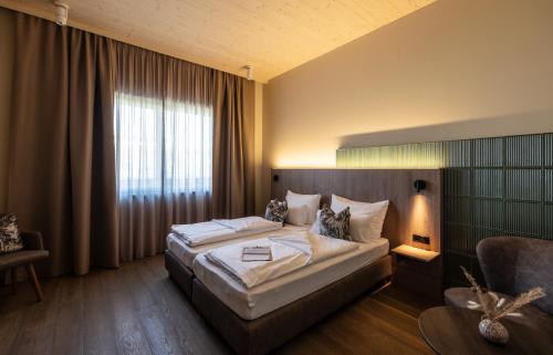 Un dormitorio con una cama grande y una ventana en Hafnerhotel - Das Kachelofen-Wohlfühlhotel en Wieselburg