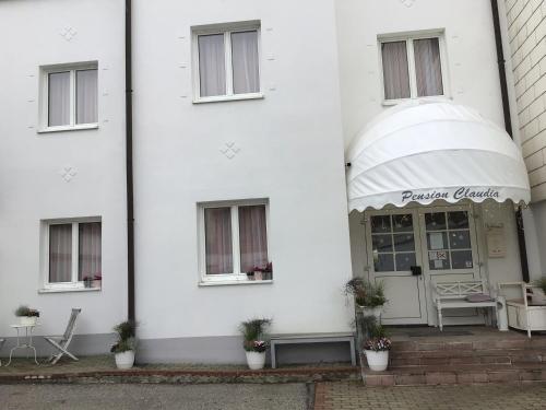 a white building with awning on the side of it at Pension Claudia in Vösendorf