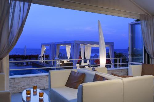 a living room with a view of the ocean at night at Victoria Frontemare Beach & Spa Hotel Jesolo in Lido di Jesolo
