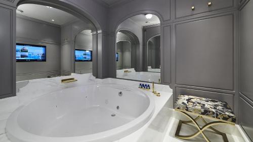 a large bathroom with a large tub and a tv at Grand Hotel Principe Di Piemonte in Viareggio