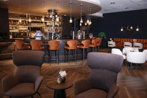 オーストザーンにあるVan der Valk Hotel Oostzaan - Amsterdamのスツール付きのレストランのバー