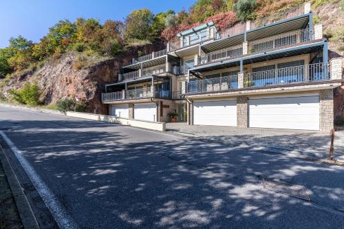 a building with two garage doors on the side of a hill at Residence Virgilio Blue in Toscolano Maderno