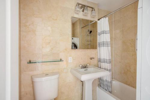 a bathroom with a sink and a toilet and a mirror at West Village 2br w in-unit wd nr shops NYC-1256 in New York