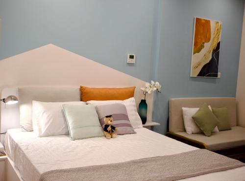 un osito de peluche sentado en una cama con almohadas en Ecopark Happy Haven, en HÆ°ng YÃªn