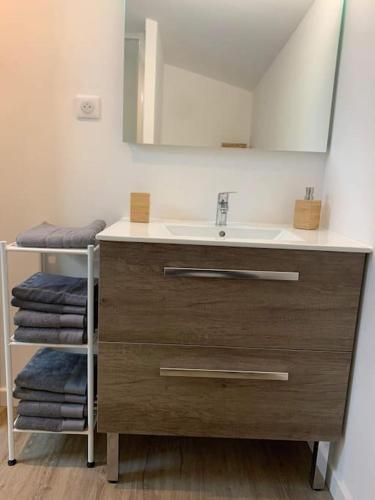 une salle de bain avec un lavabo, un miroir et des serviettes dans l'établissement Duplex au cœur du village de Cassis, à Cassis