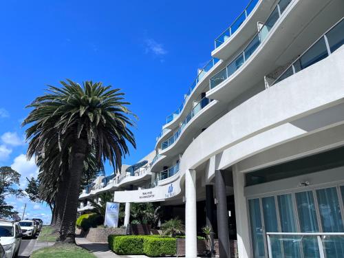 a large building with a palm tree in front of it at Waves 348 - Free WiFi - Late CheckOut - Garage in Cowes