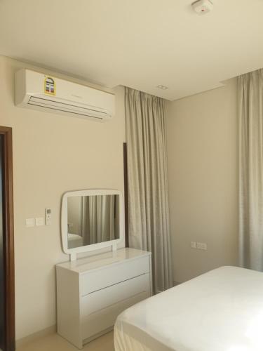 a bedroom with a bed and a tv on the wall at Peace in Sifah -Sea view in As Sīfah