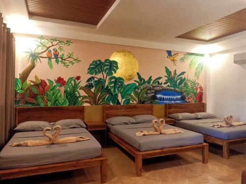 two beds in a room with a mural on the wall at Panglao Kalikasan Resort in Panglao Island
