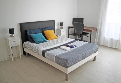 - une chambre avec un lit avec des oreillers et un bureau dans l'établissement Appartement Centre Perpignan 3 pièces 70m2 Avec Climatisation, à Perpignan