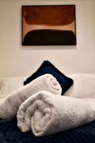 een handdoek op een bed met een foto aan de muur bij The Beach House, The Kove, Bournemouth Beach in Bournemouth