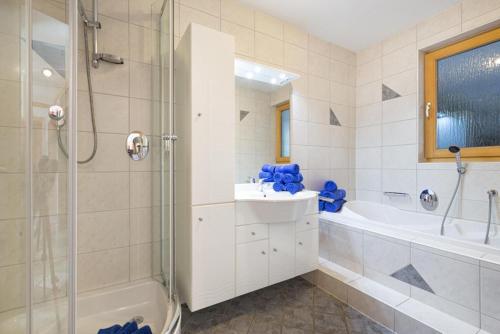 a bathroom with a shower and a sink and a tub at Bergsonnhof in Jerzens