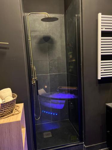 La salle de bains est pourvue d'une douche avec une porte en verre. dans l'établissement Suite64 - Jacuzzi privatif, à Neuilly-sur-Seine