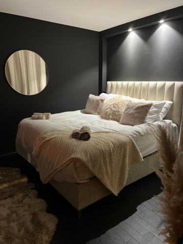 - une chambre avec un grand lit et un miroir mural dans l'établissement Suite64 - Jacuzzi privatif, à Neuilly-sur-Seine