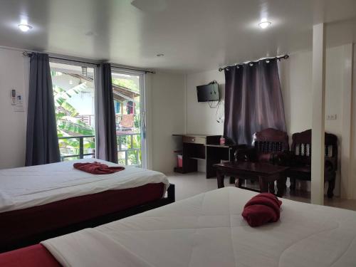 a hotel room with two beds and a window at Kitty Guesthouse in Phi Phi Islands