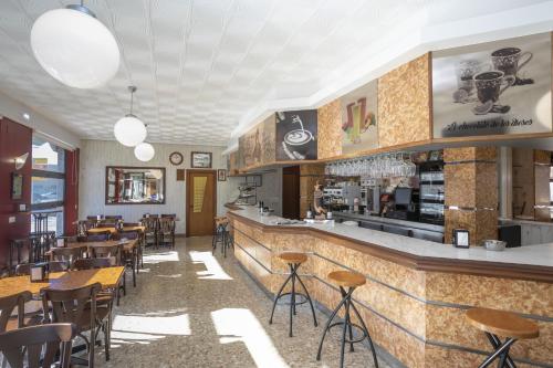 a restaurant with a bar and tables and chairs at Hotel La Ruta in Tapia de Casariego