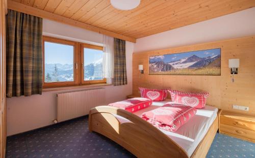 a bedroom with a bed with red pillows on it at Bergsonnhof in Jerzens