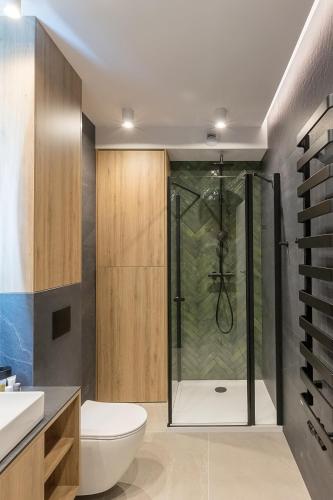 a bathroom with a shower with a toilet and a sink at Wonder Home - Domki Hillside tuż przy stoku narciarskim - na terenie kompleksu plac zabaw i zewnętrzna siłownia, sklep, parking in Karpacz