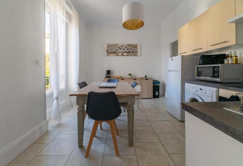 - une cuisine avec une table en bois et un comptoir dans l'établissement Le Louis - Appartement 2 chambres, proche du centre et lac, à Vichy