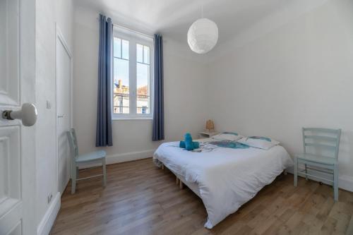 1 dormitorio con 1 cama, 1 silla y 1 ventana en Le Louis - Appartement 2 chambres, proche du centre et lac, en Vichy