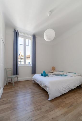 une chambre blanche avec un lit et une fenêtre dans l'établissement Le Louis - Appartement 2 chambres, proche du centre et lac, à Vichy