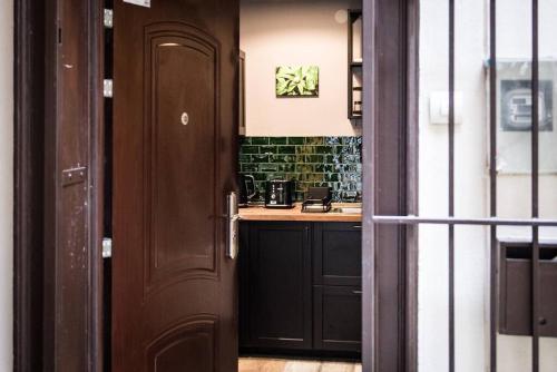 eine Tür, die in eine Küche mit einer Theke führt in der Unterkunft Budapest Boulvard Green in Budapest
