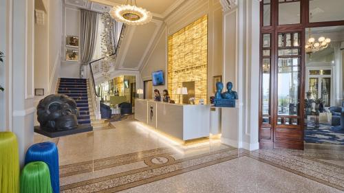 un vestíbulo con una estatua en el centro de un edificio en Grand Hotel Principe Di Piemonte en Viareggio