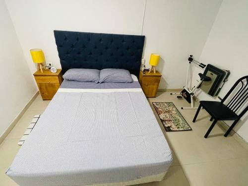 a bedroom with a large white bed and a chair at bedroom and private bathroom Habitacion y baño privado - en una casa in Cordoba