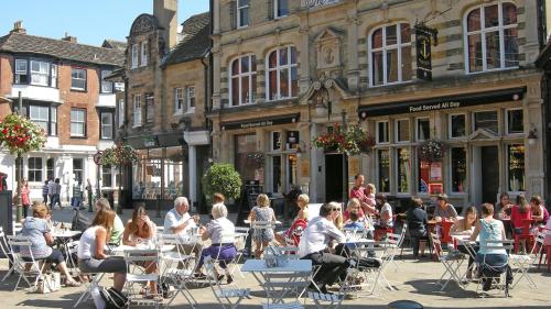 a group of people sitting at tables in front of buildings at KB21 Attractive 2 Bed House, pets/long stays with easy links to London, Brighton and Gatwick in Roffey