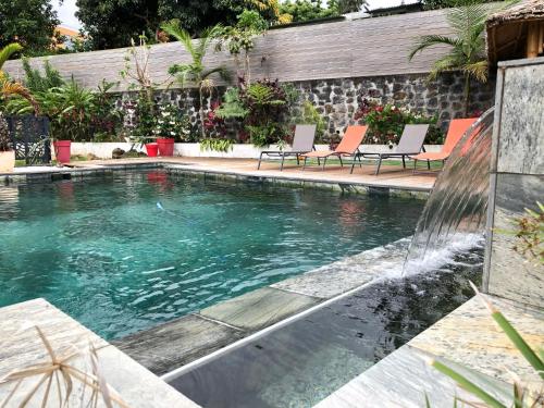 einen Pool mit Stühlen im Hinterhof in der Unterkunft Charmant rez de jardin avec acces piscine in Le Tampon
