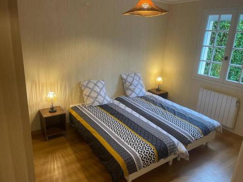 una camera con un letto con due lampade su due tavoli di Maison plain-pied hyper centre ville Perros a Perros-Guirec