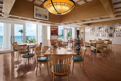 a dining room with tables and chairs and a chandelier at The Westin Resort Guam in Tumon