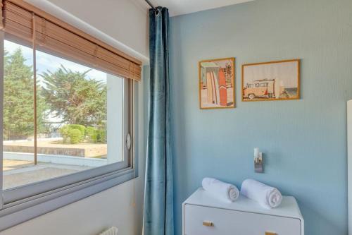 La salle de bains bleue est pourvue d'une fenêtre et de toilettes. dans l'établissement Vue mer La Baule : L'escale Bauloise, à La Baule