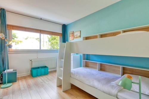 - une chambre avec des lits superposés et un mur bleu dans l'établissement Vue mer La Baule : L'escale Bauloise, à La Baule