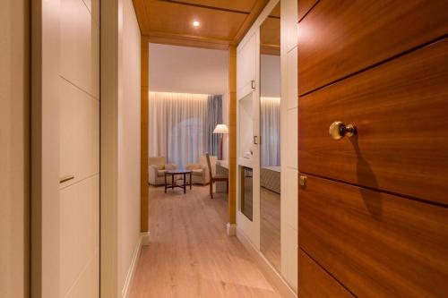 un corridoio con porta e una stanza con tavolo di Smy Carlos V Wellness & Spa Alghero ad Alghero