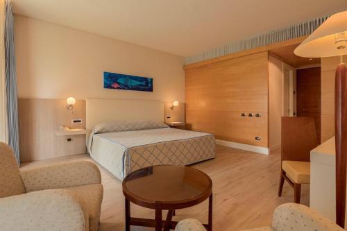 um quarto de hotel com uma cama e uma mesa em Smy Carlos V Wellness & Spa Alghero em Alghero