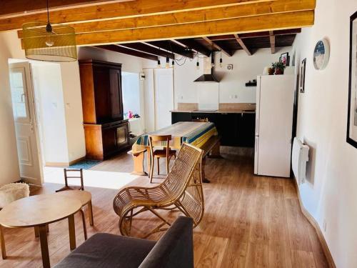 une cuisine et un salon avec une table et des chaises dans l'établissement Cottage Romy Siouville Hague, à Siouville