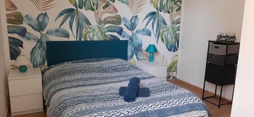 - une chambre avec un lit à tête bleue dans l'établissement EMERAUDE, à Nantes