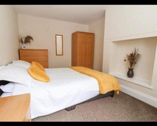 布里德靈頓的住宿－Rosie’s rest，卧室配有白色的床,上面有黄色的毯子