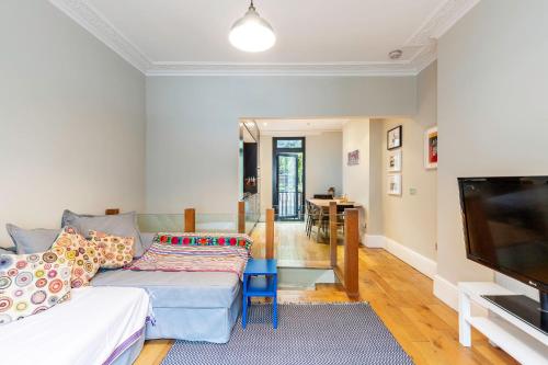 a living room with a couch and a flat screen tv at Beautiful two-bed abode Near King Cross in London