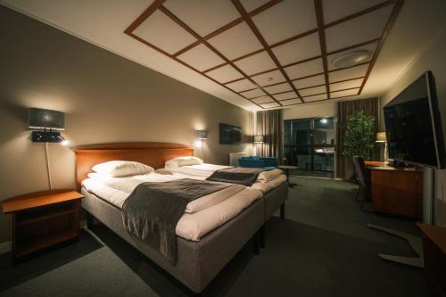 sypialnia z dużym łóżkiem i telewizorem w obiekcie Scandic Harstad w mieście Harstad