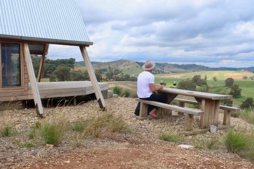 un hombre sentado en una mesa de picnic con vistas en Kimo Estate, en Gundagai