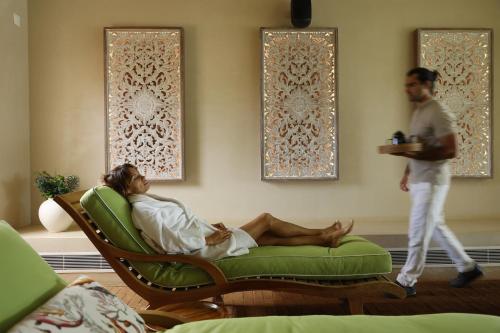 a woman laying on a couch in a room with a man at Praia do Canal Nature Retreat - Small Luxury Hotels of the World in Aljezur
