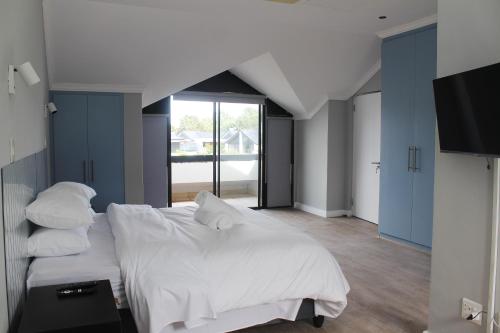 ein Schlafzimmer mit einem großen Bett mit weißen Laken und Kissen in der Unterkunft Pearl Valley Golf Lodge - loadshedding free in Simondium