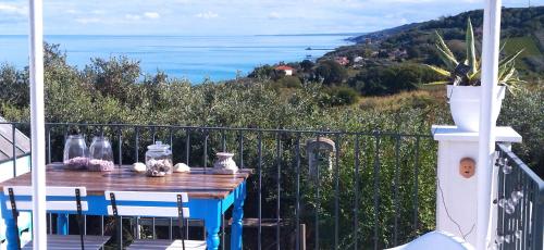a table on a balcony with a view of the ocean at La collina sui trabocchi in Ortona