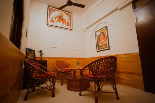 une salle à manger avec trois chaises et une table dans l'établissement KARNI VILAS, à Jaipur