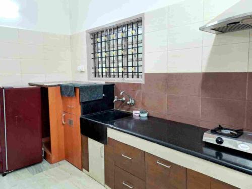 a kitchen with a black counter and a sink at Airport 7min/rela 5min/Kitchen/AC/Wifi/Bedroom1 in Chennai