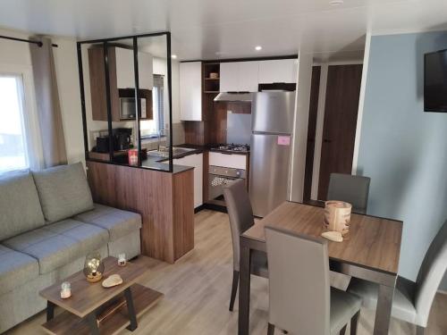 een keuken en woonkamer met een tafel en een bank bij Ô Coeur d'Eden ,2 mobilhomes l'Ôriginal et le BÔ'Aime in Piriac-sur-Mer