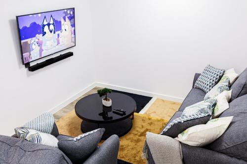 a living room with two couches and a tv at Beautifully Fab 3 bedroom 4 beds New home 8 guests Stretford Trafford in Manchester
