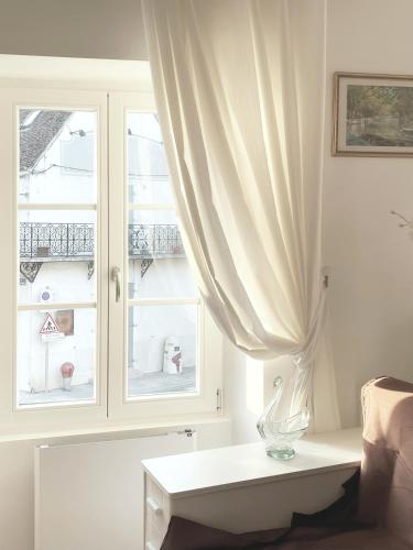 a white living room with a window and a table at Place Sainte Marguerite in Provins